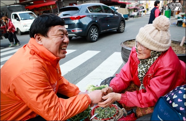 ▲ 울산 동구에 출마한 무소속 김종훈 후보가 동울산시장에서 나물을 파는 할머니와 손을 잡고 얘기를 나누고 있다.
