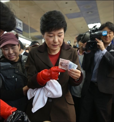 ▲2012년 11월 부산 자갈치 시장을 방문한 박근혜 후보가 8천원을 꺼내는 모습 ⓒ공동취재기자단