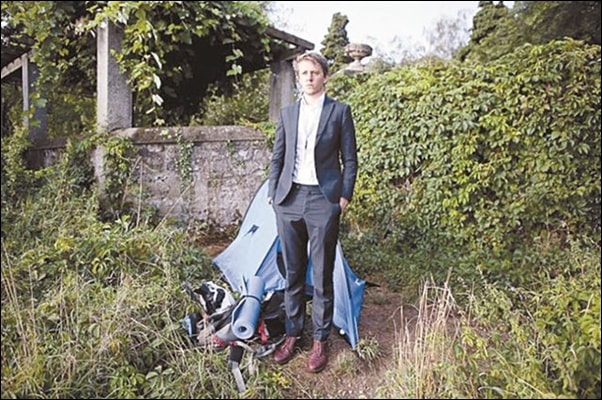 ▲유엔에서 무급 인턴으로 일하고 있는 뉴질랜드 청년 데이비드 하이드가 노숙 생활을 하고 있는 파란색 텐트 앞에서 유엔 신분증을 목에 걸고 서 있다. ⓒ제네바 트리뷴 트위터.