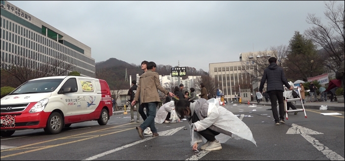 ▲전두환씨가 떠나자, 광주지방법원 앞 도로에 있던 쓰레기를 줍는 광주 시민들