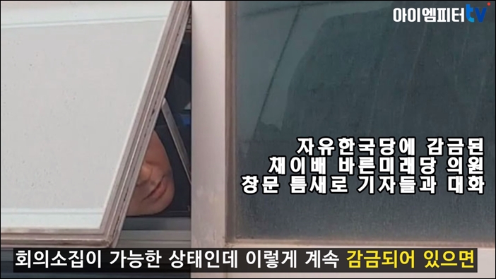 ▲채이배 의원이 자유한국당 의원의 감금으로 창문 틈새를 통해 기자들과 대화를 하는 모습