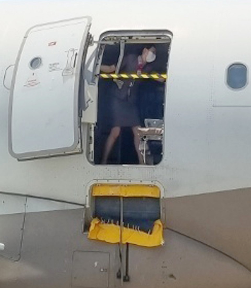 ▲지난 26일 오후 제주공항에서 출발해 대구공항에 비상구 출입문이 열린 채 착륙한 아시아나항공기에서 한 승무원이 문에 안전바를 설치한 뒤 두 팔을 벌려 막고 있다 ⓒ대구공항 제공