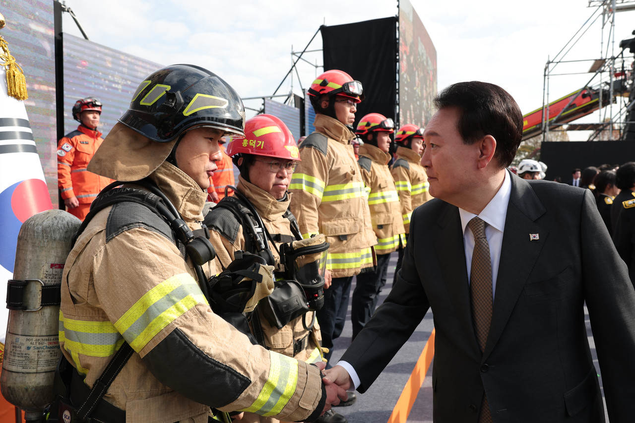 ▲윤석열 대통령이 9일 서울 용산어린이정원 잔디마당에서 열린 제61주년 소방의 날 기념식에서 소방관들을 격려하고 있다.ⓒ대통령실 제공 