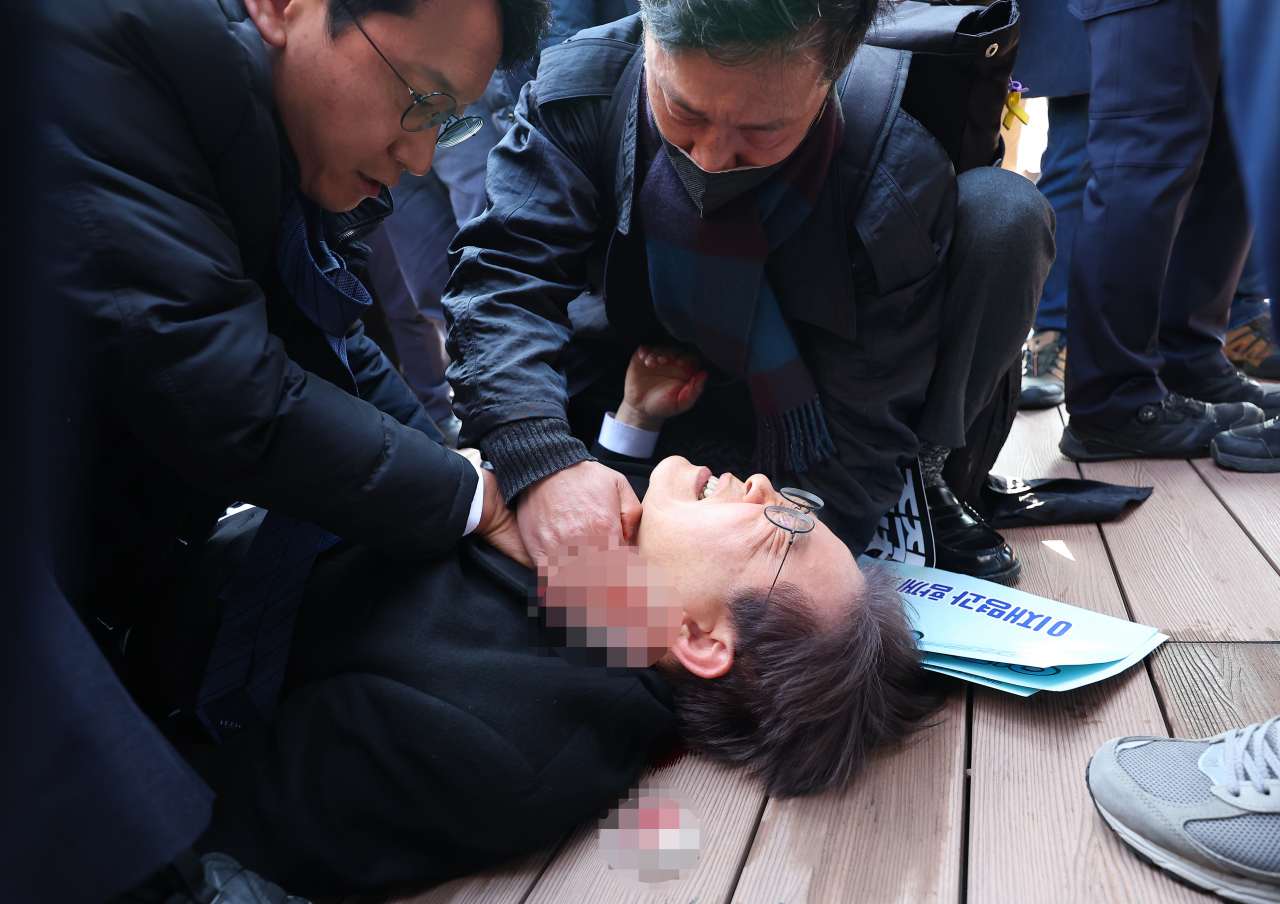 ▲ 더불어민주당 이재명 대표가 2일 오전 부산 강서구 가덕신공항 부지를 둘러본 뒤 왼쪽 목 부위 피습을 당해 바닥에 누워 응급조치를 받고 있다. ⓒ연합뉴스 