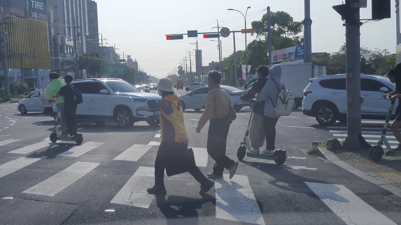 ▲거리에서 안전 헬멧도 없이 두 사람씩 공유 전동킥보드를 타는 학생들 