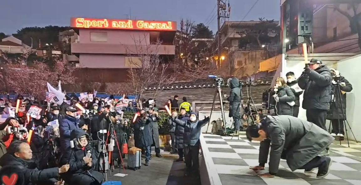 ▲ 윤석열 대통령의 변호인단에 참여한 석동현 변호사가 한남동 관저에 모인 탄핵 저지 집회에서 대통령의 인사를 전한다며 큰 절을 하고 있는 모습 © 유튜브 이영풍TV 갈무리