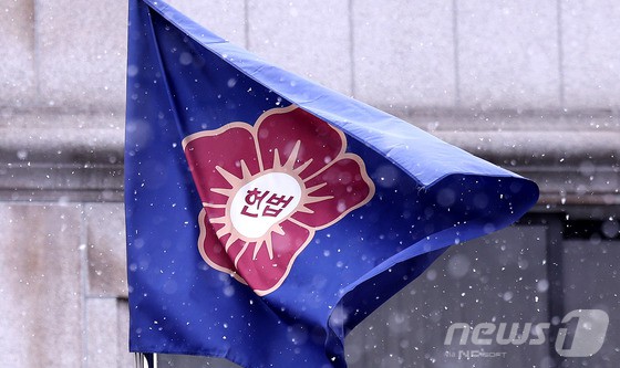 ▲ 윤석열 대통령에 대한 헌법재판소의 탄핵 심판이 소추일 기준으로 100일을 훌쩍 넘기며 연일 최장 기록을 경신하고 있는 가운데 30일 서울 종로구 헌재 깃발이 눈발과 함께 펄럭이고 있다.헌법재판소가 3월 내 선고일을 지정하지 않으면서 탄핵 심판 결론은 결국 4월로 넘어가게 됐다. 일각에서는 4월 중순이나 5~6월 선고설까지 나오는 모습이다.