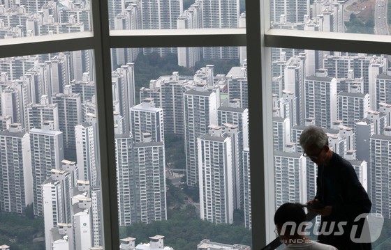 서울 아파트의 74%에 해당하는 127만 6257가구가 정부의 주택담보대출(주담대) 한도 6억 원 제한 조치로 직접적인 영향을 받을 것으로 예상된다. 지난 28일부터 시행된 이번 규제로 서울 25개 구 중 18개 구에서 기존보다 대출 가능액이 크게 줄어들 전망이다.29일 부동산R114 분석에 따르면 서울 아파트 평균 시세는 14억 6000만 원에 달하지만 대출 한도가 6억 원으로 제한되면서 평균 8억 6000만 원 이상의 현금이 있어야 입주가 가능하다. 사진은 이날 서울 송파구 서울스카이전망대에서 바라본 송파구 아파트단지 모습.